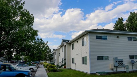 a row of houses with cars parked in front of them