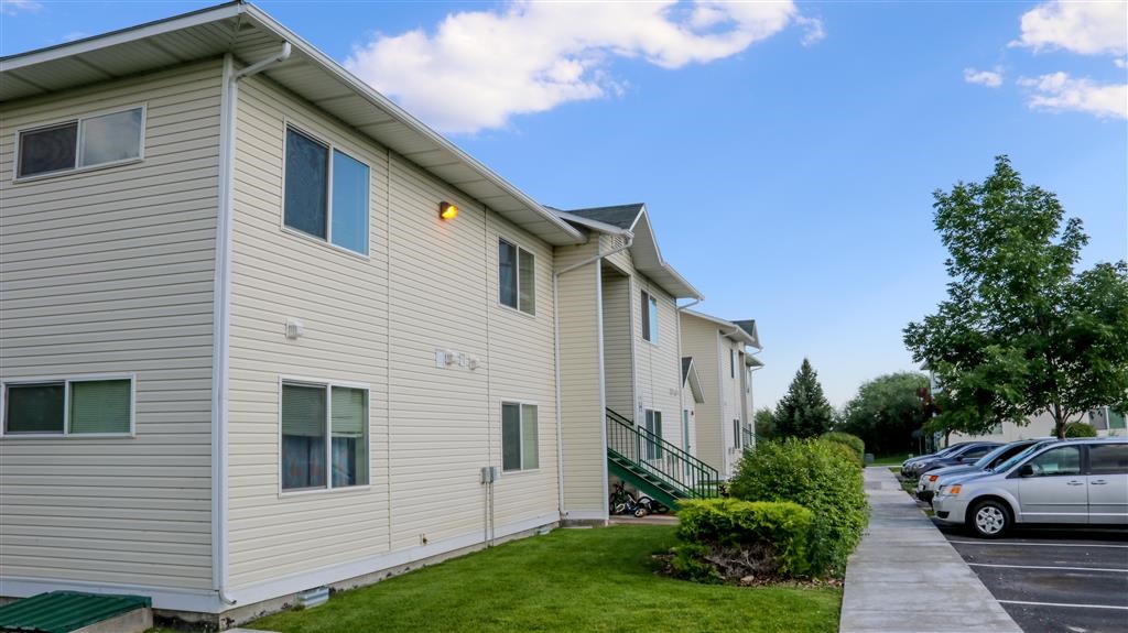 a row of houses with cars parked in a parking lot