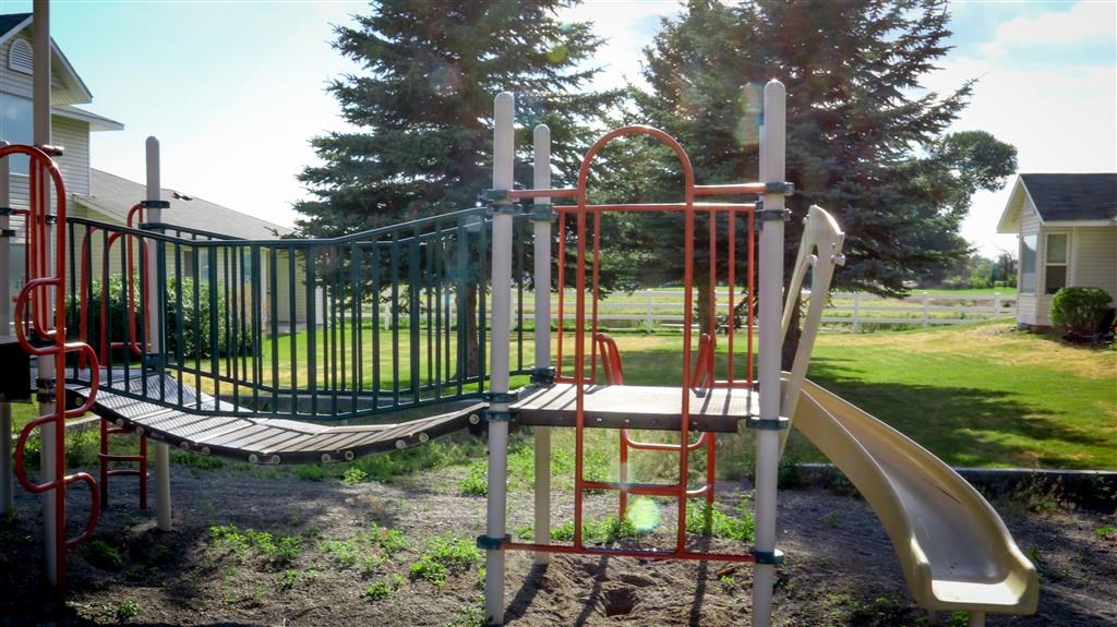 a swing set and slide in a playground