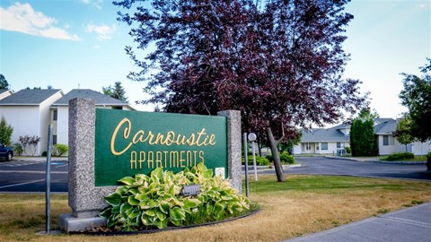 a green sign sitting in front of a building