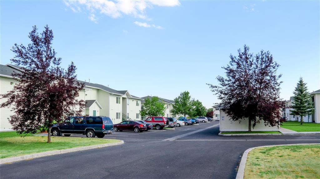a city street with cars parked in front of houses