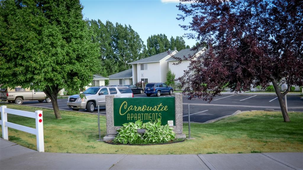 a sign for theocatee apartments on the side of a street