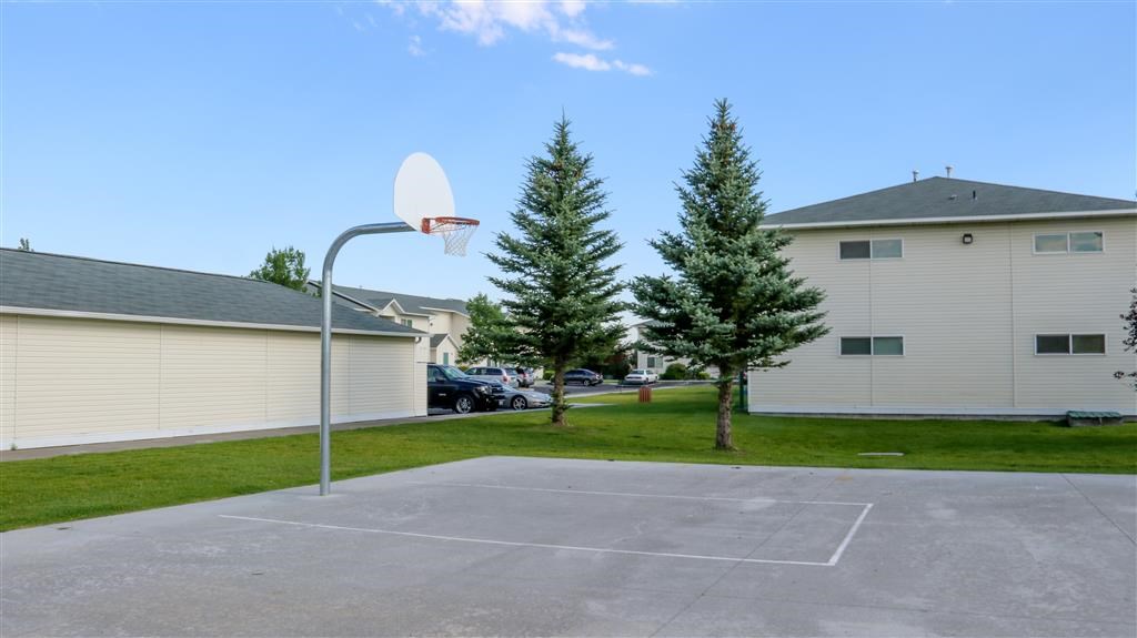a basketball hoop in a parking lot next to two houses