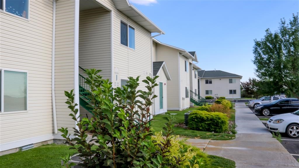 a row of houses with cars parked in front of them