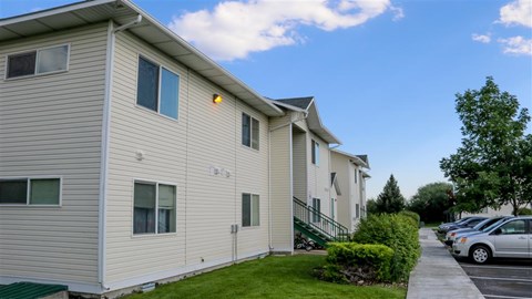 a row of houses with cars parked in a parking lot