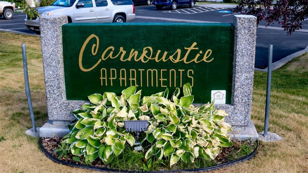 a sign for carousels apartments on the side of a street