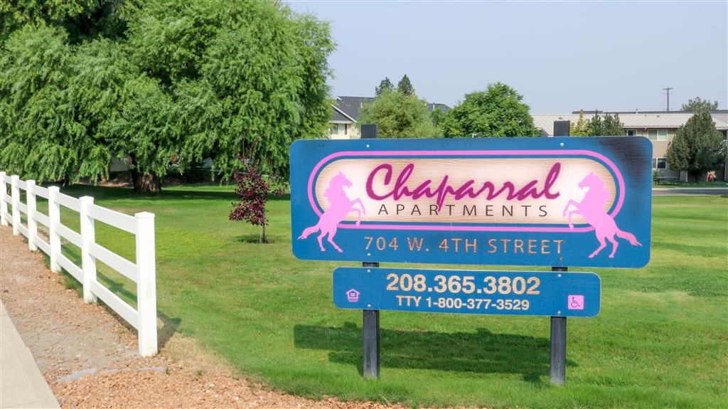 a sign for the olympic apartments on the side of a field