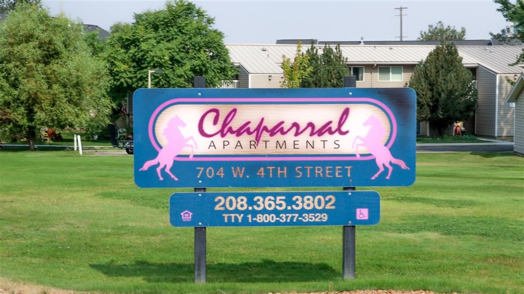 a sign that says channahal apartments in front of a field