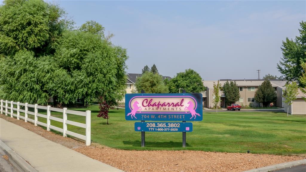 a sign for a restaurant on the lawn of a park