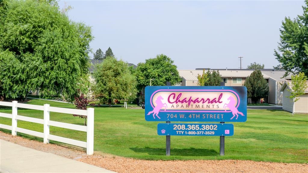 a sign for a restaurant on the lawn of a street