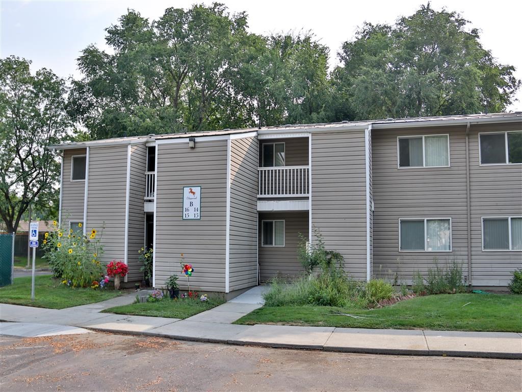 an apartment building with grey siding and a sidewalk