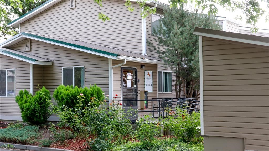 a gray house with a garden in front of it