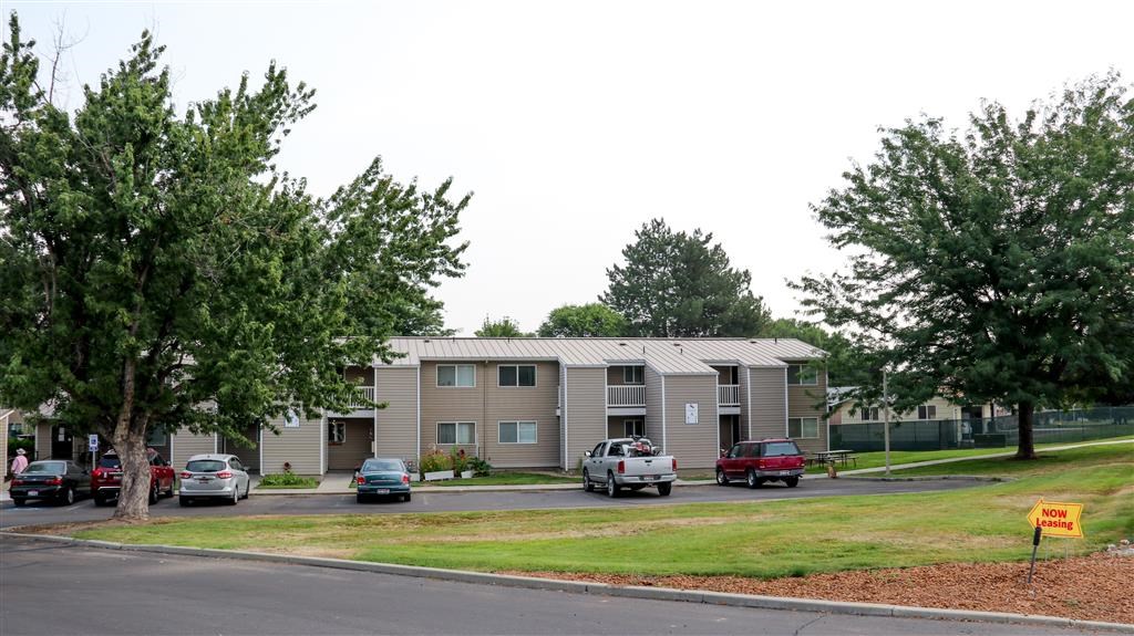 an apartment building with cars parked in front of it