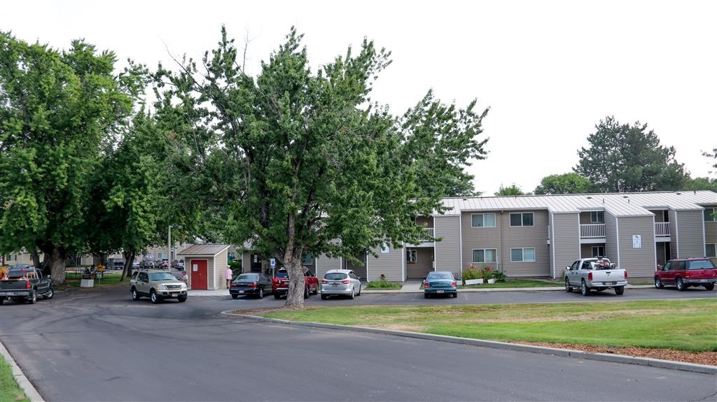 a street with cars parked in front of apartment buildings