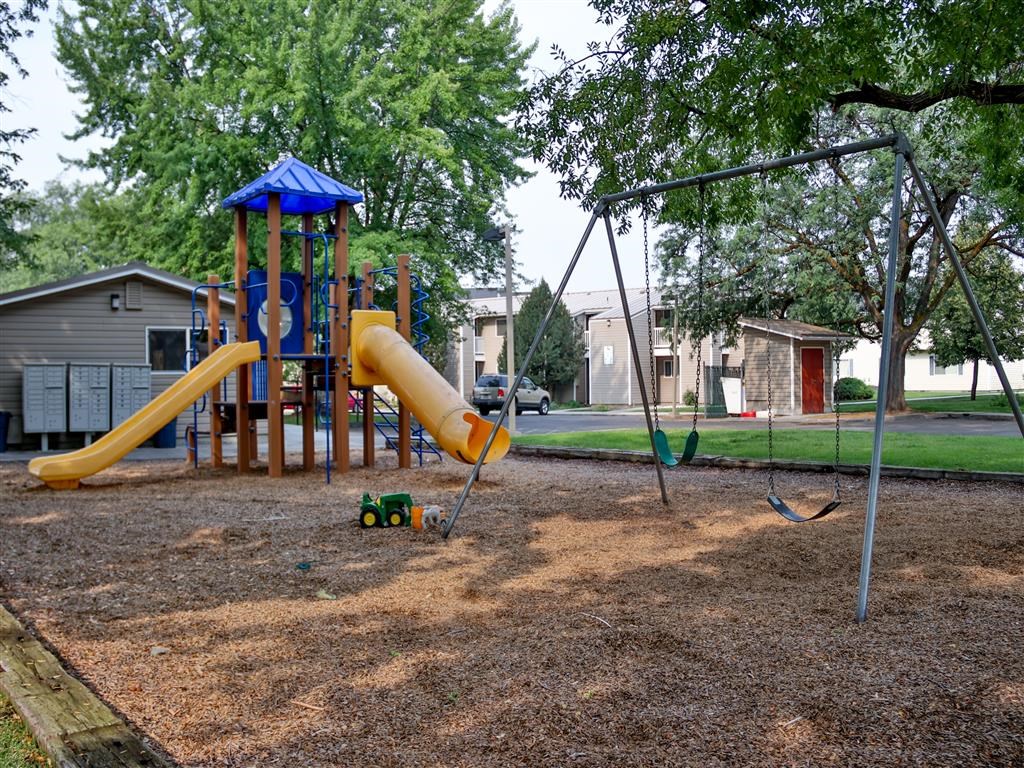 a playground with a swing set and a slide