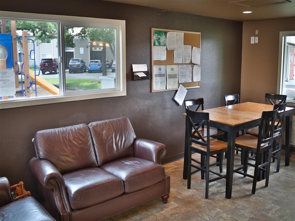 a seating area with a couch table and chairs and a window