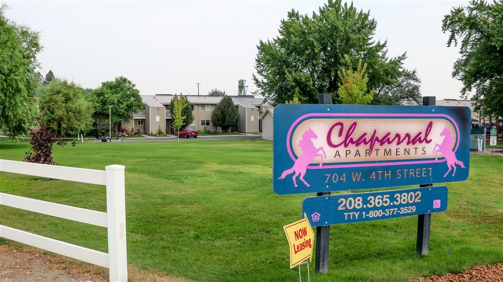 a sign that is in front of a grass field