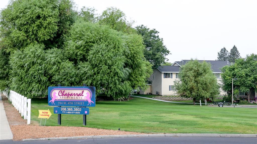 a sign in front of a yard with a house