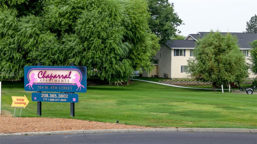 a sign in front of a yard with a house