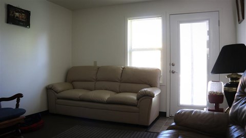 a living room with a couch and two windows