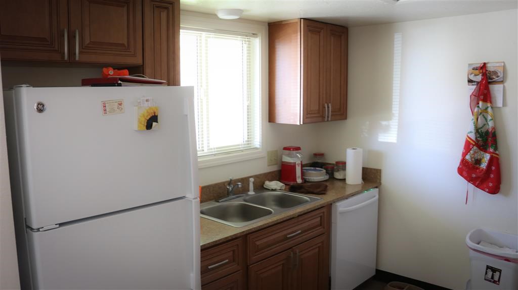 a kitchen with a white refrigerator and a sink