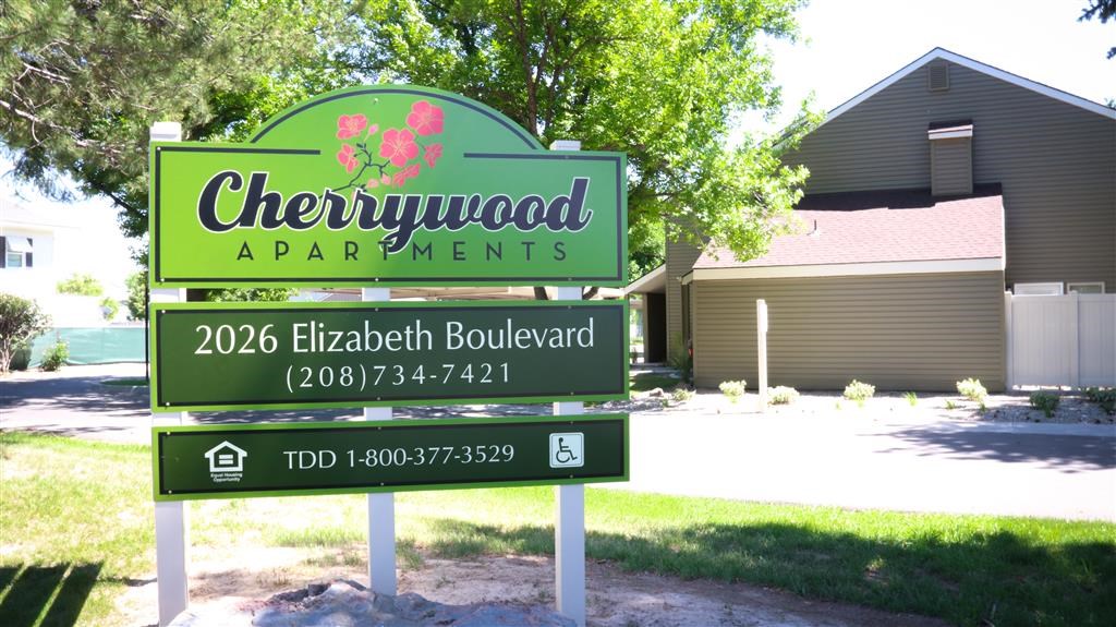 a sign for chewywood apartments in front of a house
