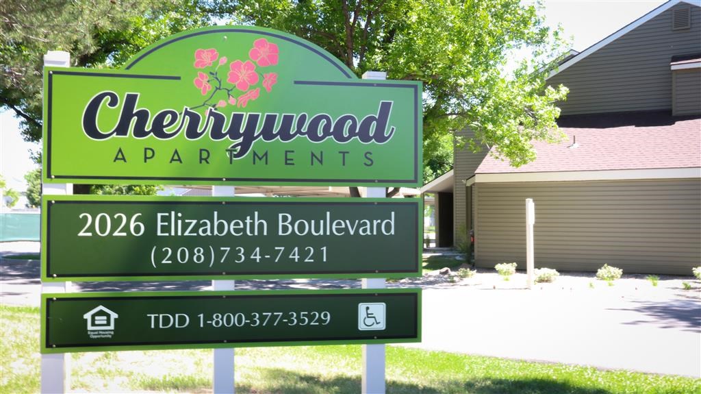 a sign for chewywood apartments in front of a house