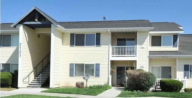 a yellow house with a sidewalk in front of it