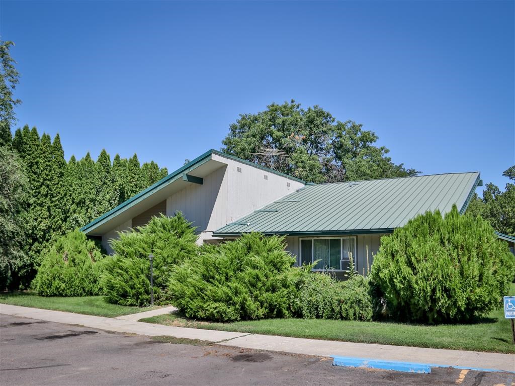 a green and white house with a green roof