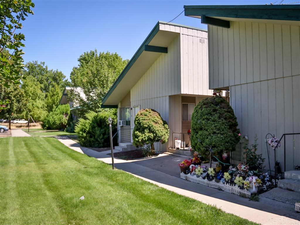 a white building with a flower garden in front of it
