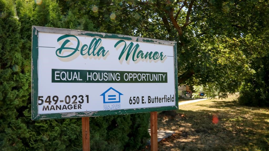 a real estate sign in front of a tree