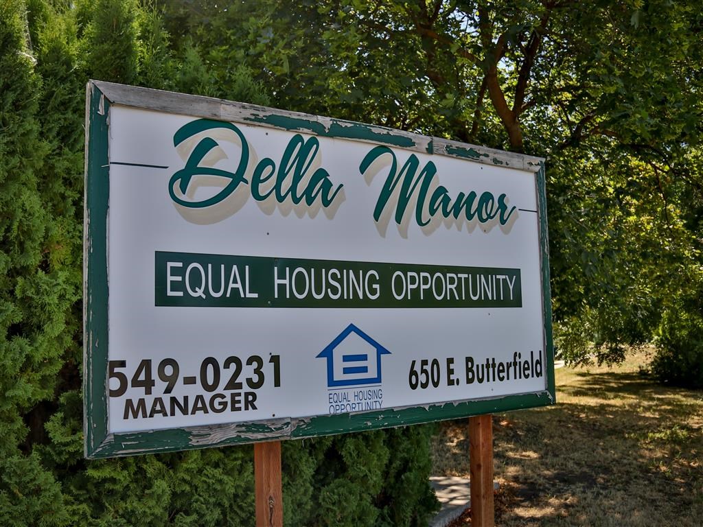 a sign manera equal housing opportunity manager in front of trees