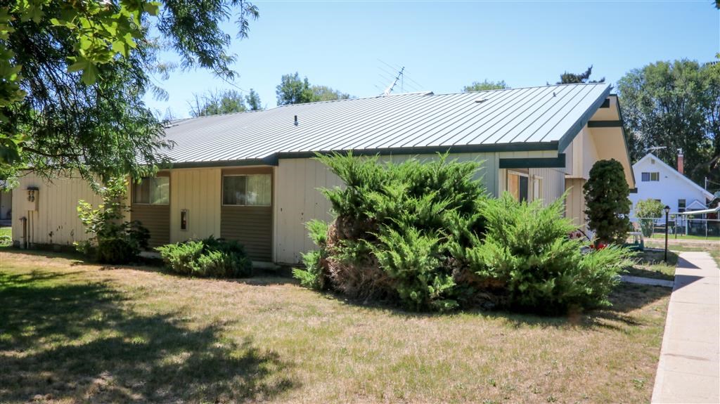 a house with a metal roof and some bushes