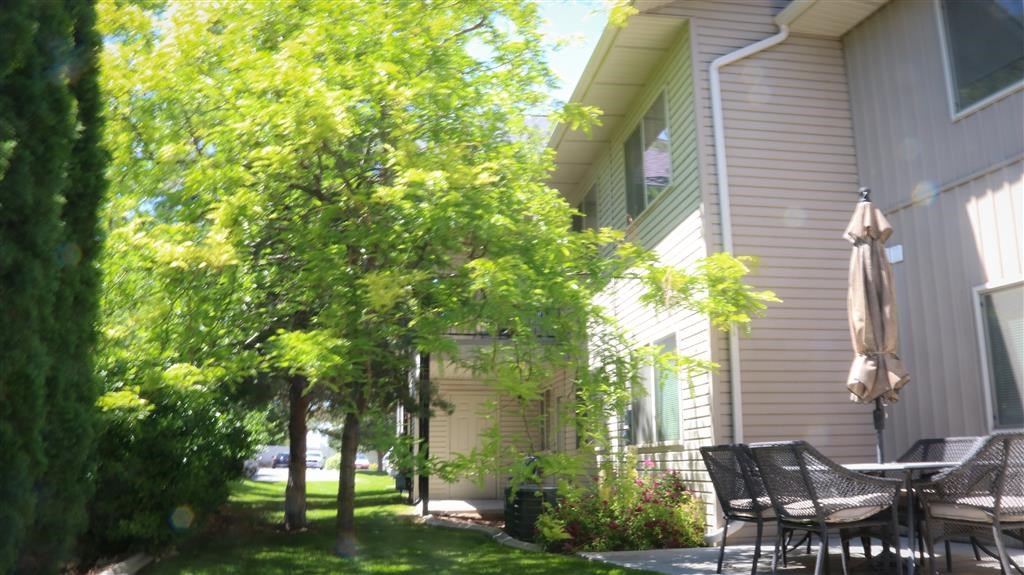 a patio with chairs and an umbrella in front of a house