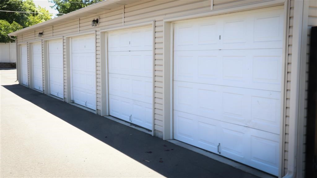 three white garage doors on the side of a building
