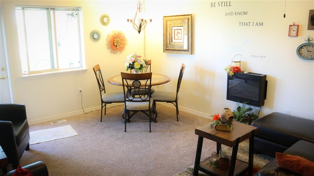 a living room with a dining room table and a television