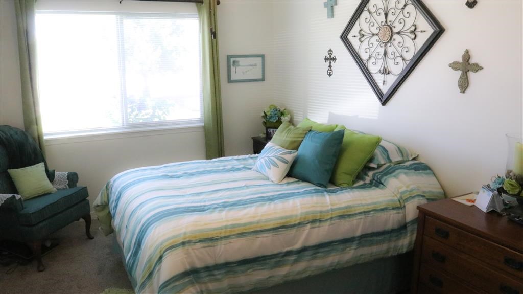 a bedroom with a bed with blue and green pillows
