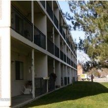 an apartment building with a lawn outside of it