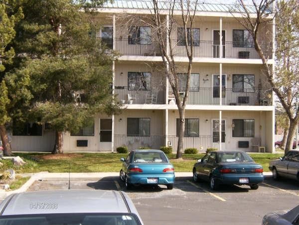 three cars parked in a parking lot in front of an apartment building