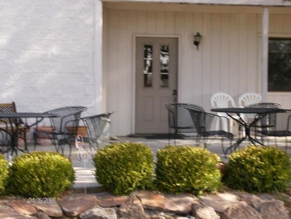 a porch with tables and chairs and a white door