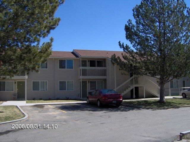 a red car parked in front of an apartment building