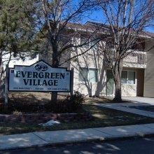 the evergreen village sign in front of a house