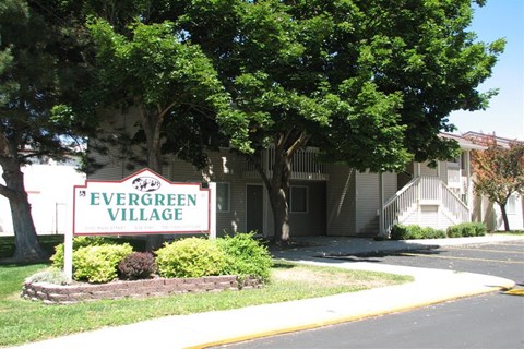 a sign for evergreen village in front of a building