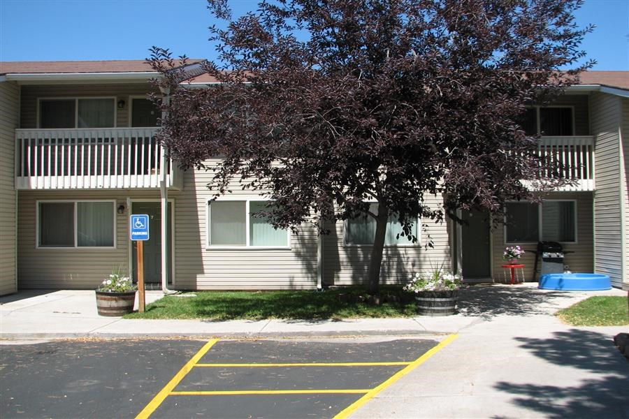 an empty parking lot in front of an apartment building