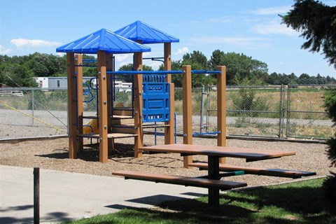 a playground with a swing set and a picnic table
