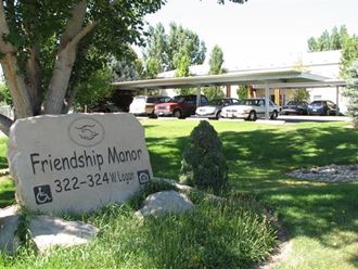 a sign for friendship manor in front of a parking lot