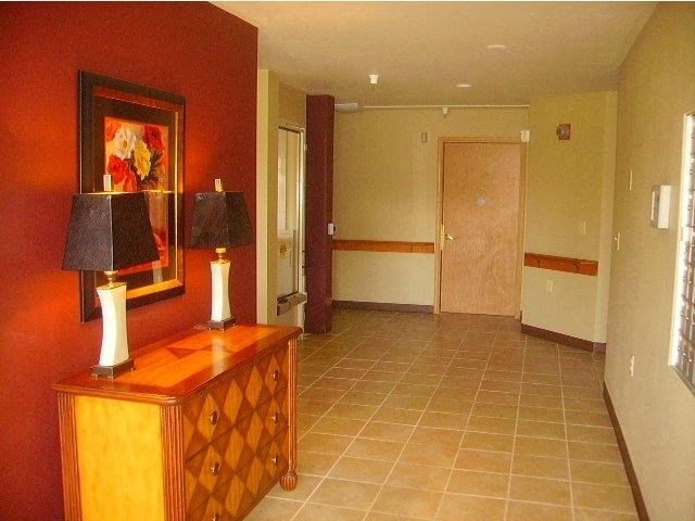 a living room with a dresser and a painting