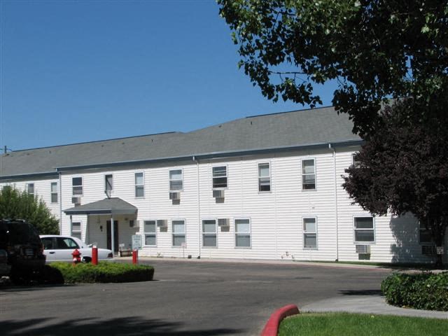 a large white building with a car parked in front of it
