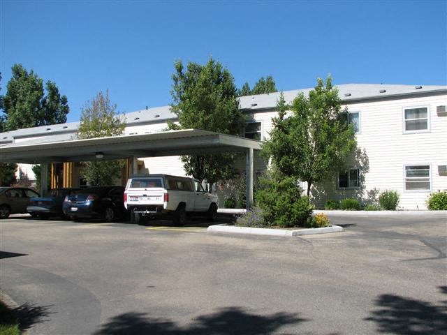 a white building with cars parked in a parking lot