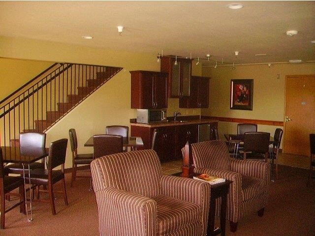 a living room with couches and chairs and a kitchen